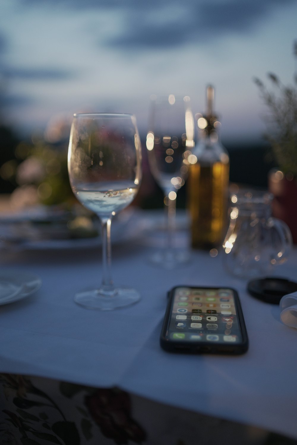 Celular sobre a mesa ao lado de uma taça de vinho